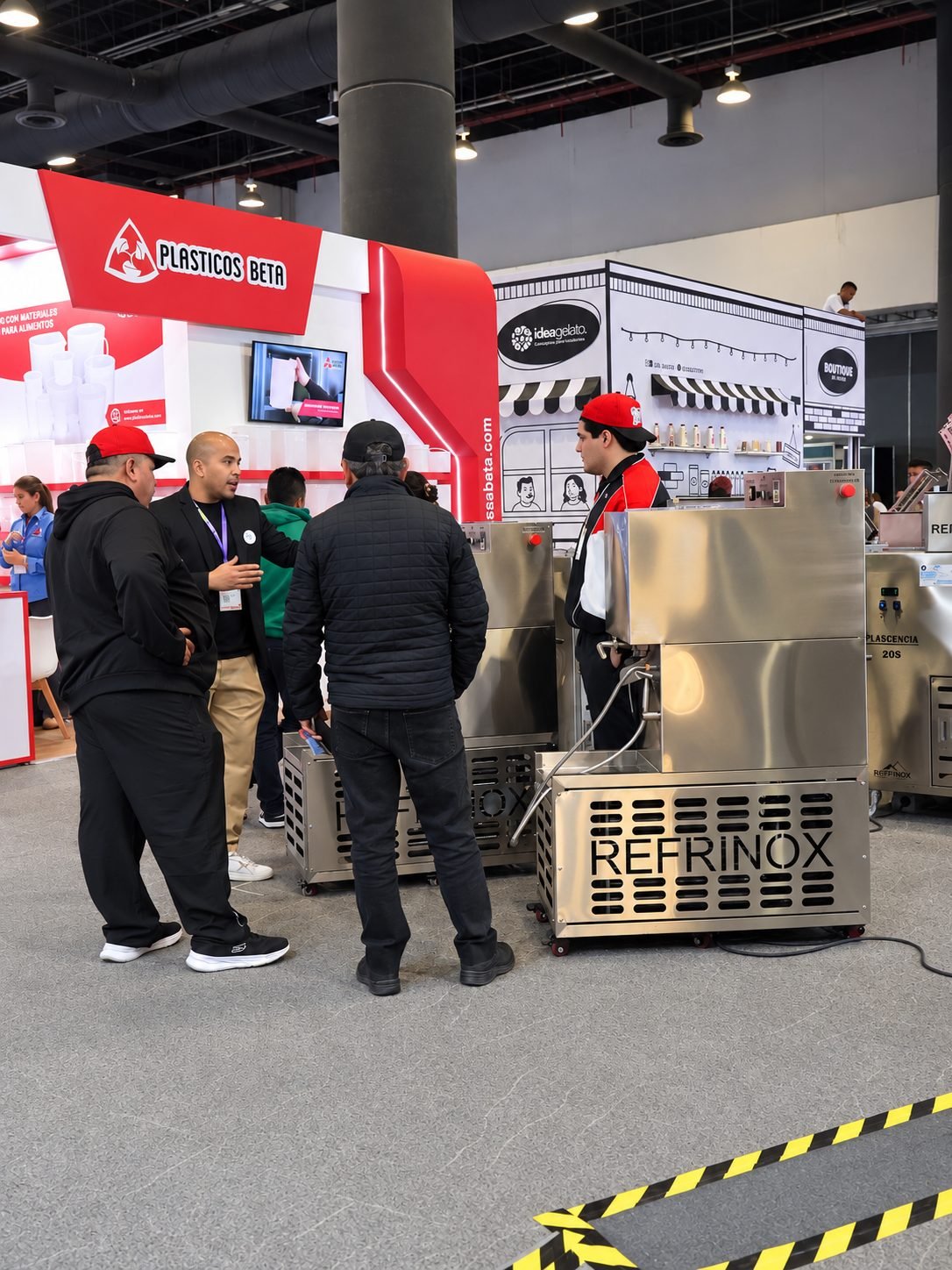 Stand de Refrinox en una exposición internacional con visitantes revisando la maquinaria